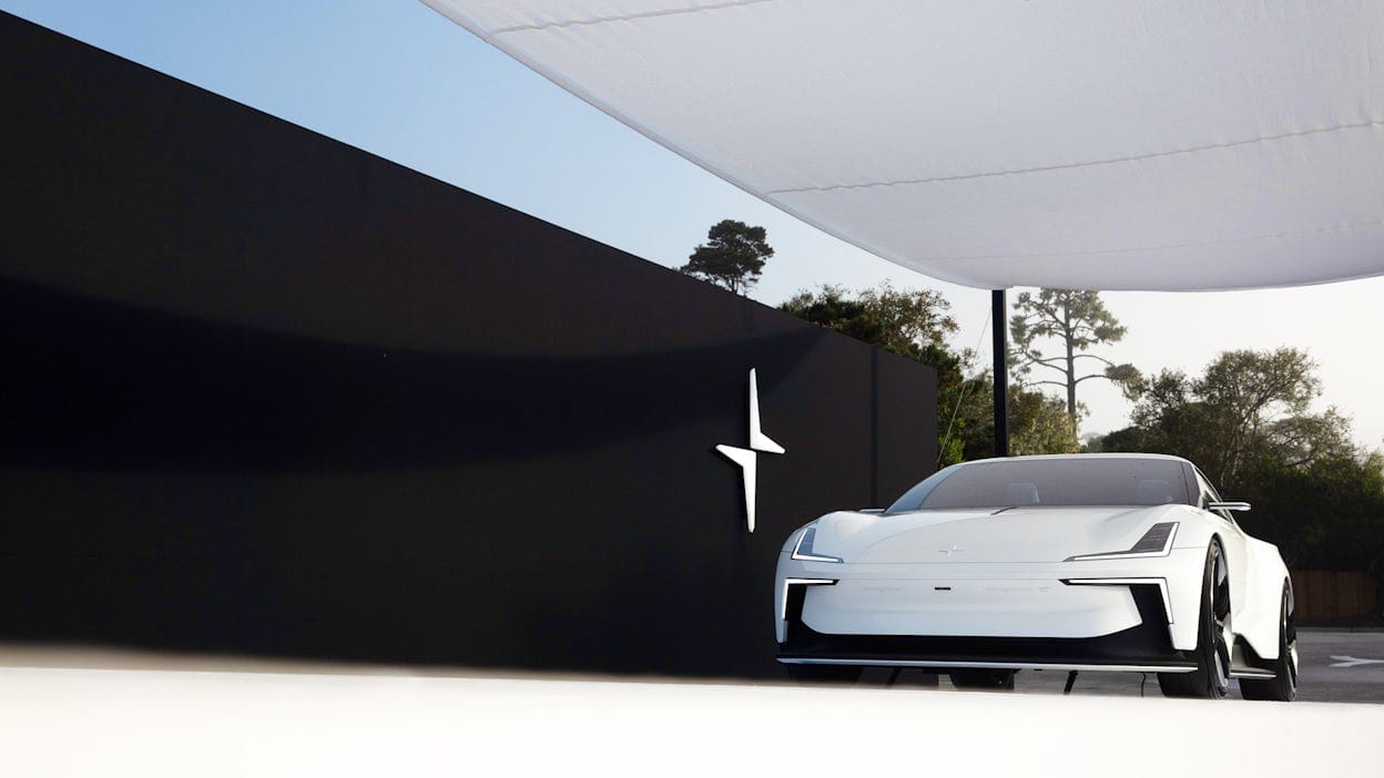 A white Polestar 6 displayed next to a black wall at Pebble Beach.