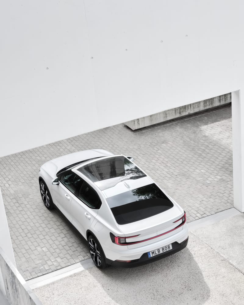 Bird's eye view of a Polestar 2 driving out of a garden