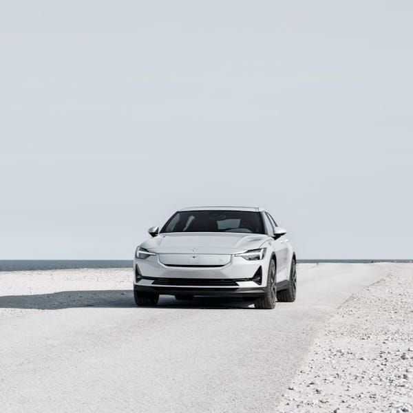 Polestar 2 parked on gravel road.