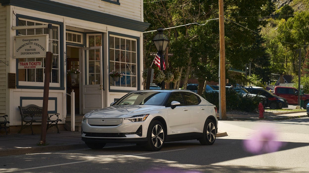 White Polestar 2 parked outside an old school tourist information centre in Georgetown.