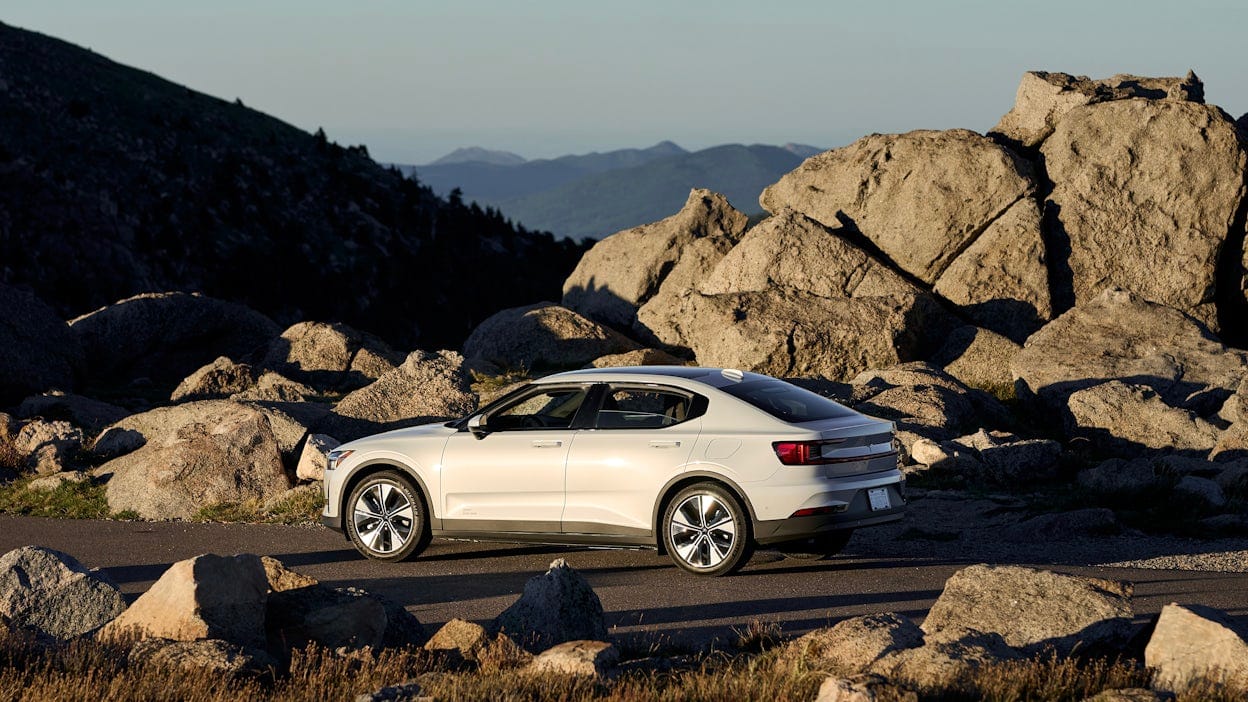 Side view of a white Polestar 2 in a rocky landscape.