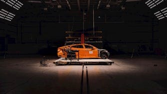 Polestar 5 sits in the middle of crash test facility surrounded by lights