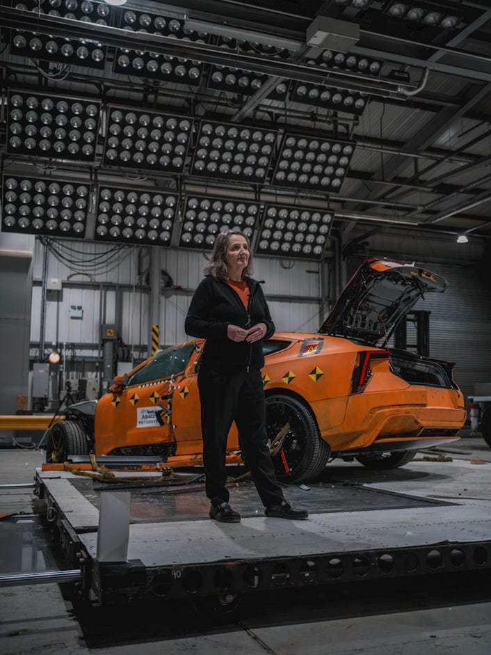 Polestar engineer stands in front of Polestar 5 in crash test facility